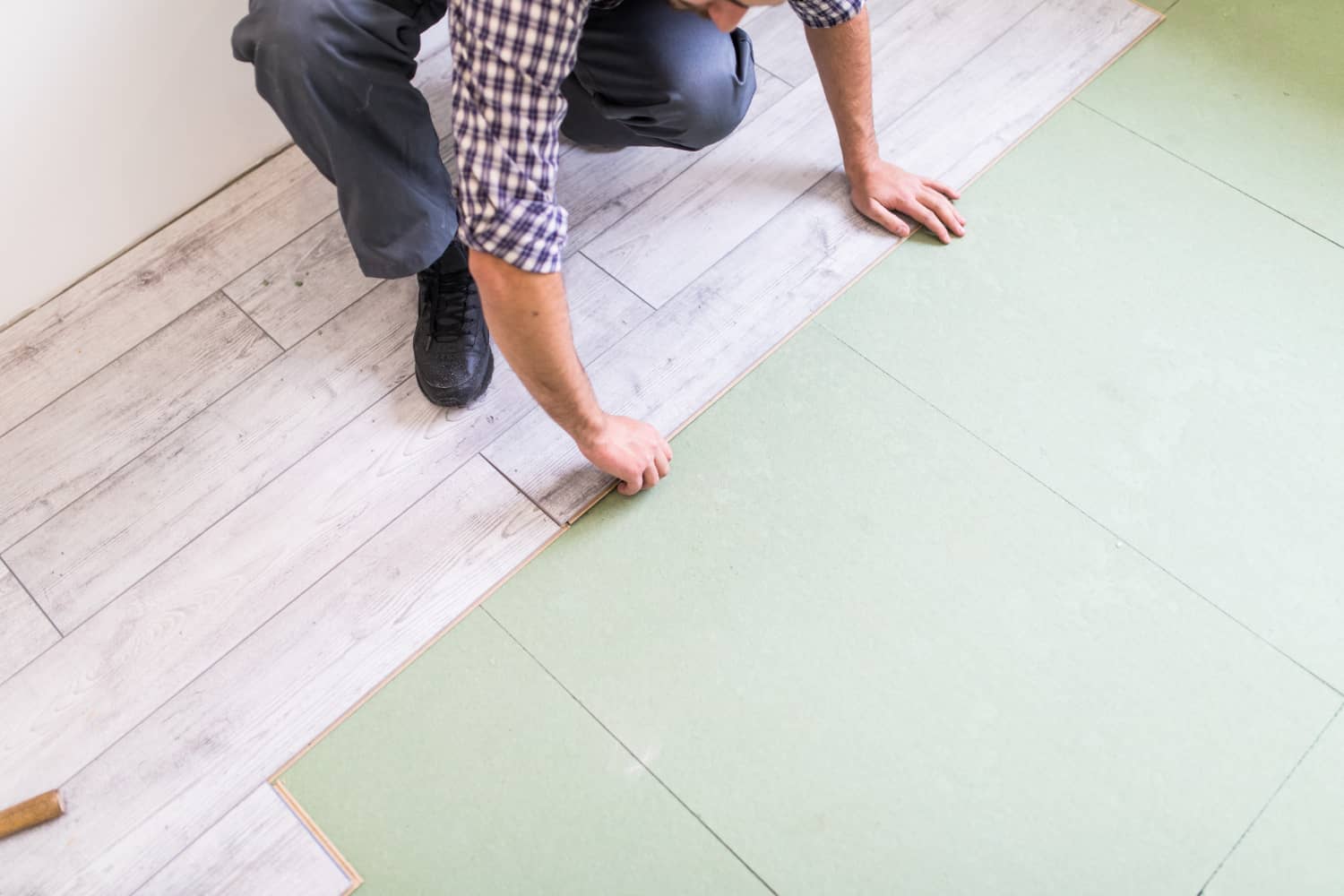 worker-processing-floor-with-bright-laminated-flooring-boards